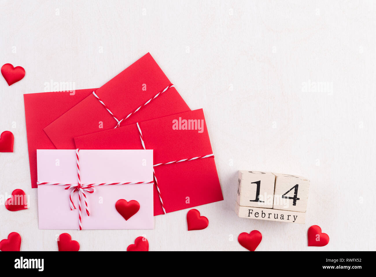 Valentines Tag und liebe Konzept. Rote Herzen und rot rosa Anschreiben und Februar 14 Texte auf hölzernen Block auf weißem Holz- Hintergrund. Stockfoto