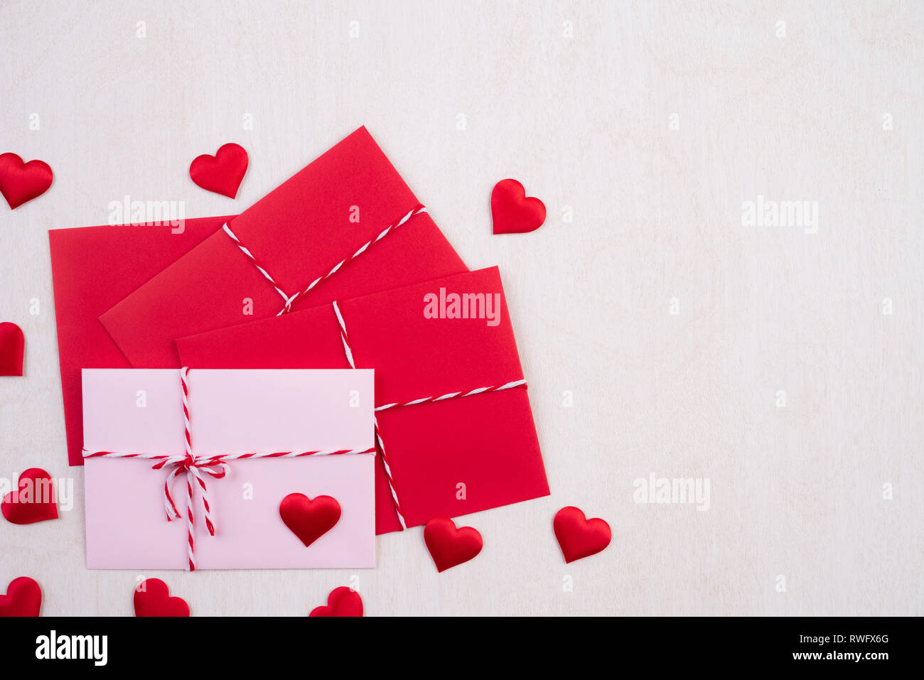Valentines Tag und liebe Konzept. Rote Herzen und rot rosa Anschreiben auf weißem Holz- Hintergrund. Stockfoto