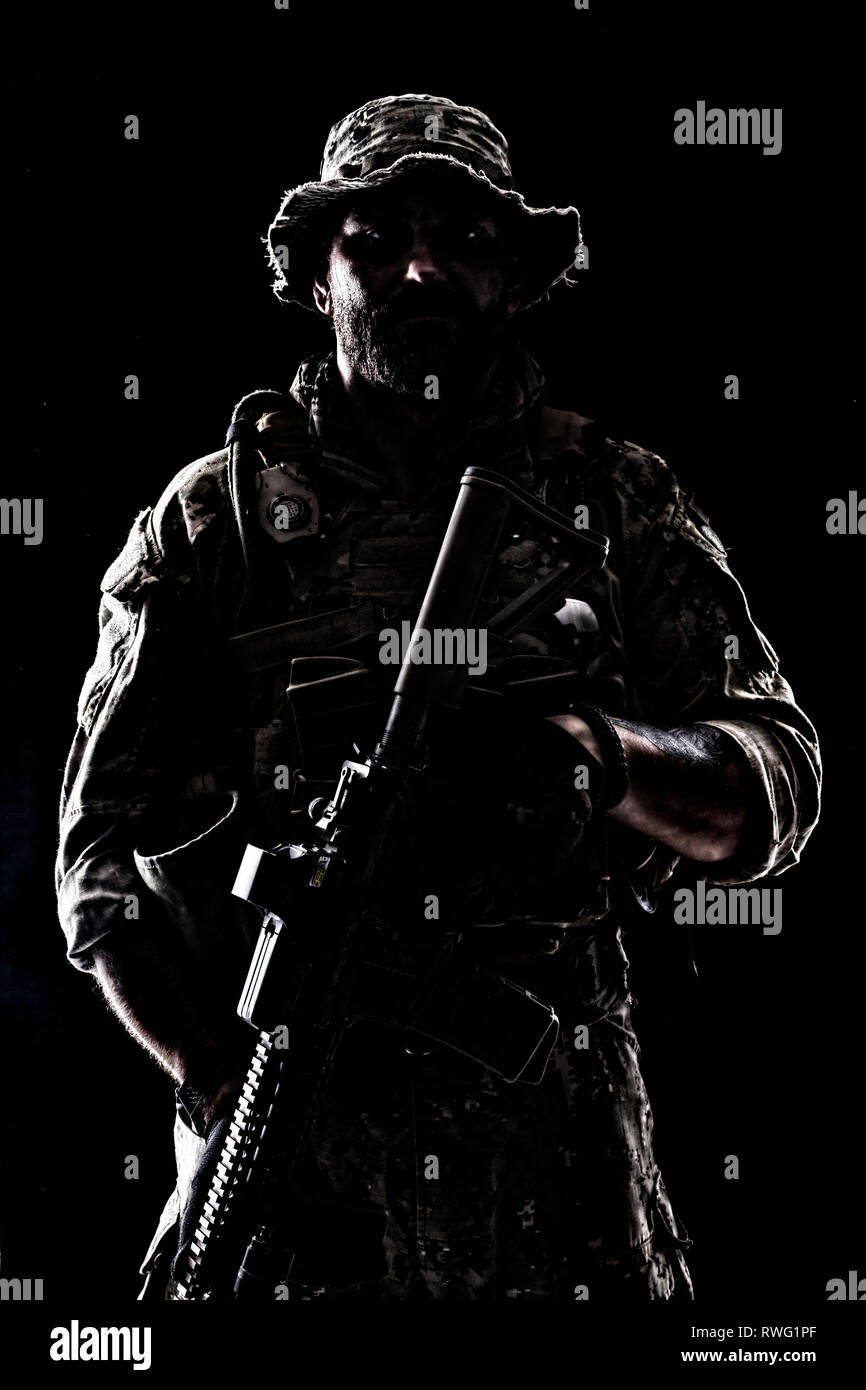 Kontur Hintergrundlicht Porträt des bärtigen Special forces Soldat in Uniform mit Waffe. Stockfoto