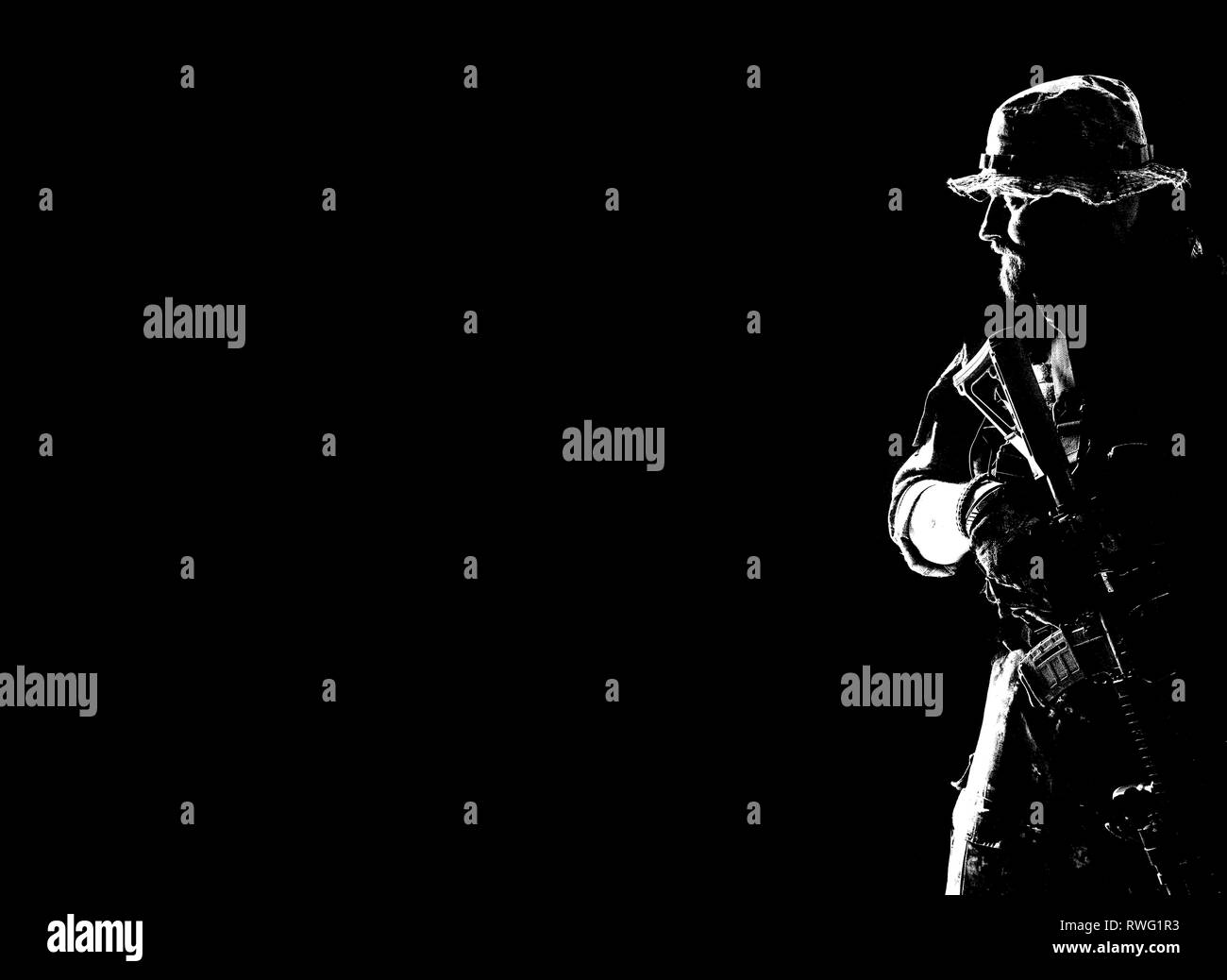 Kontur Hintergrundlicht Porträt des bärtigen Special forces Soldat in Uniform mit Waffe. Stockfoto