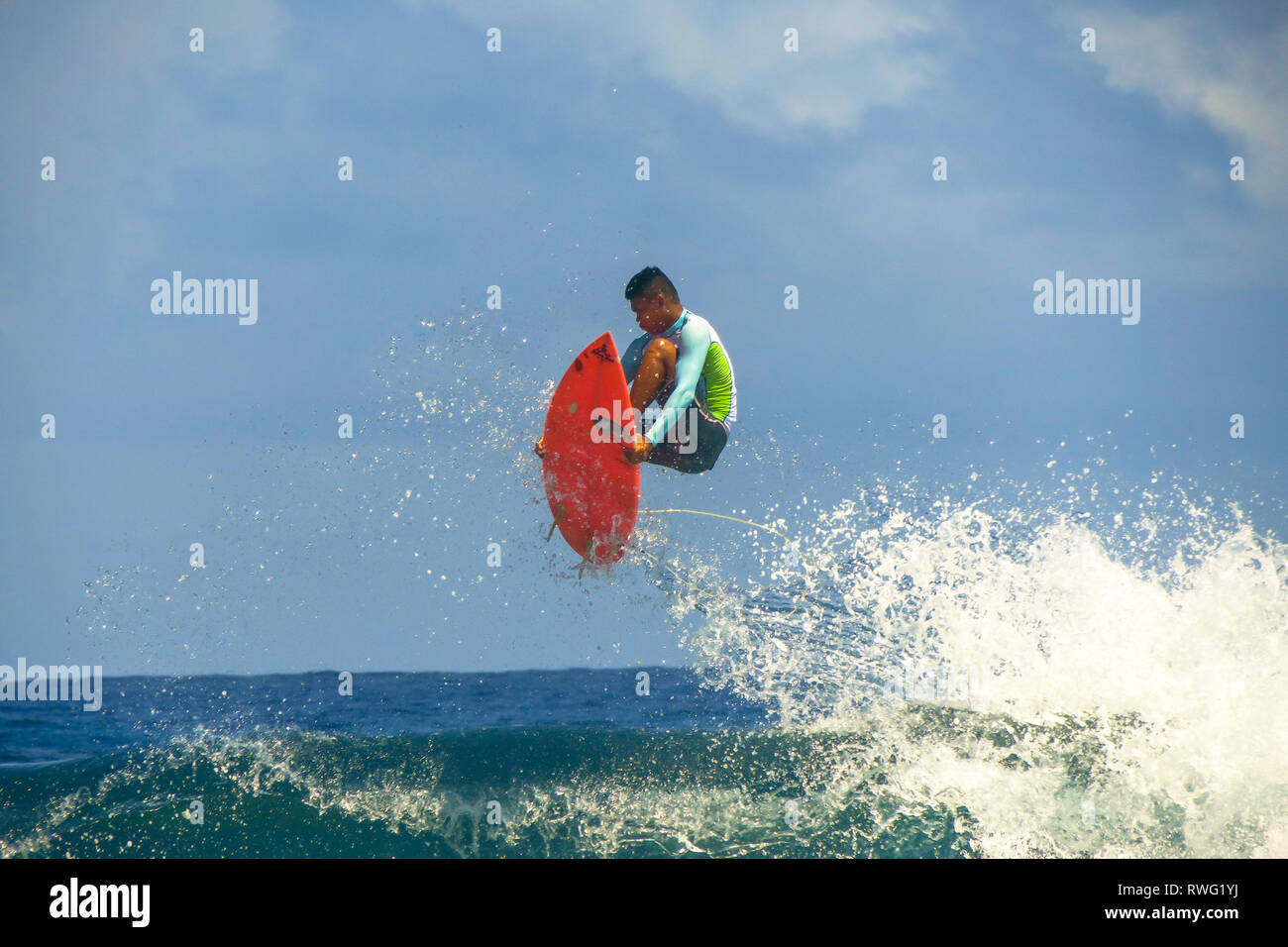 Surfer springen Welle auf Kleine rote Surfbrett surfen Wolke 9, Siargao - Philippinen Stockfoto