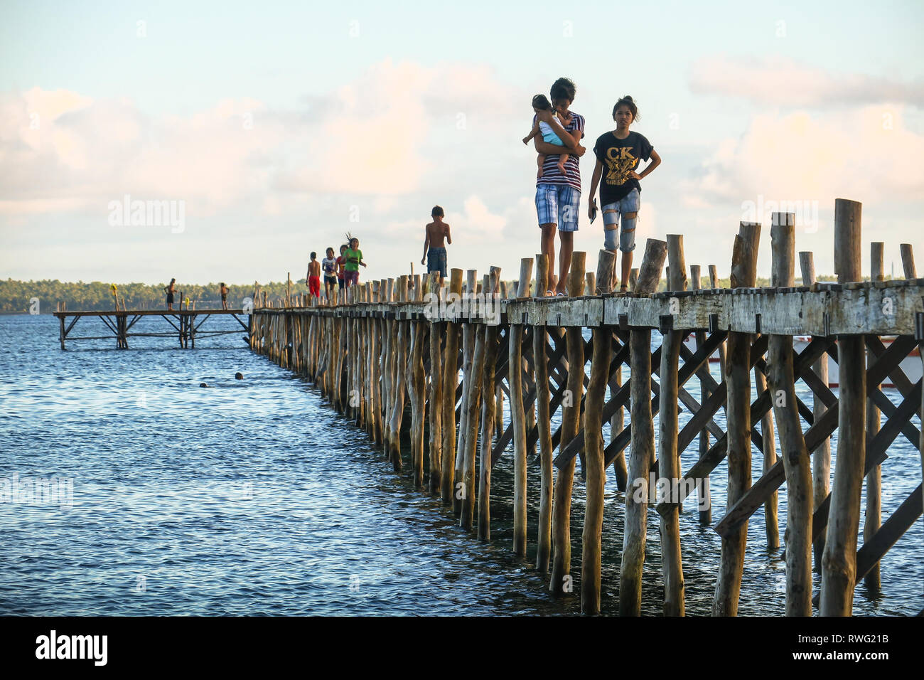 Junge philippinische Familie mit Baby, Gehen hinunter Island Pier - Allgemeine Luna, Siargao, Philippinen Stockfoto