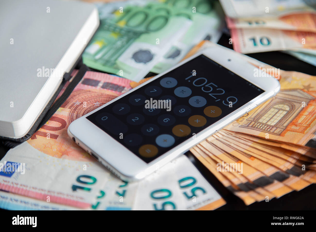 Mit Taschenrechner Anwendung auf viele Euro Banknoten Geld und eröffnet Notebook Business Konzept Smartphone Stockfoto