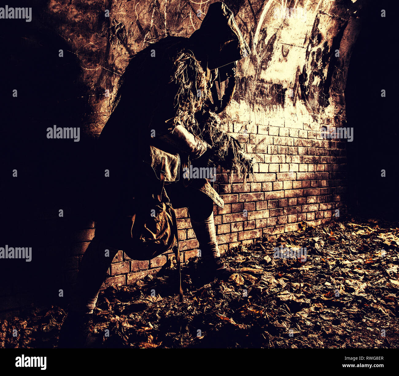 Post-apokalyptischen Kreatur in Lumpen und Gasmaske gekleidet, versteckt in Dungeon. Stockfoto