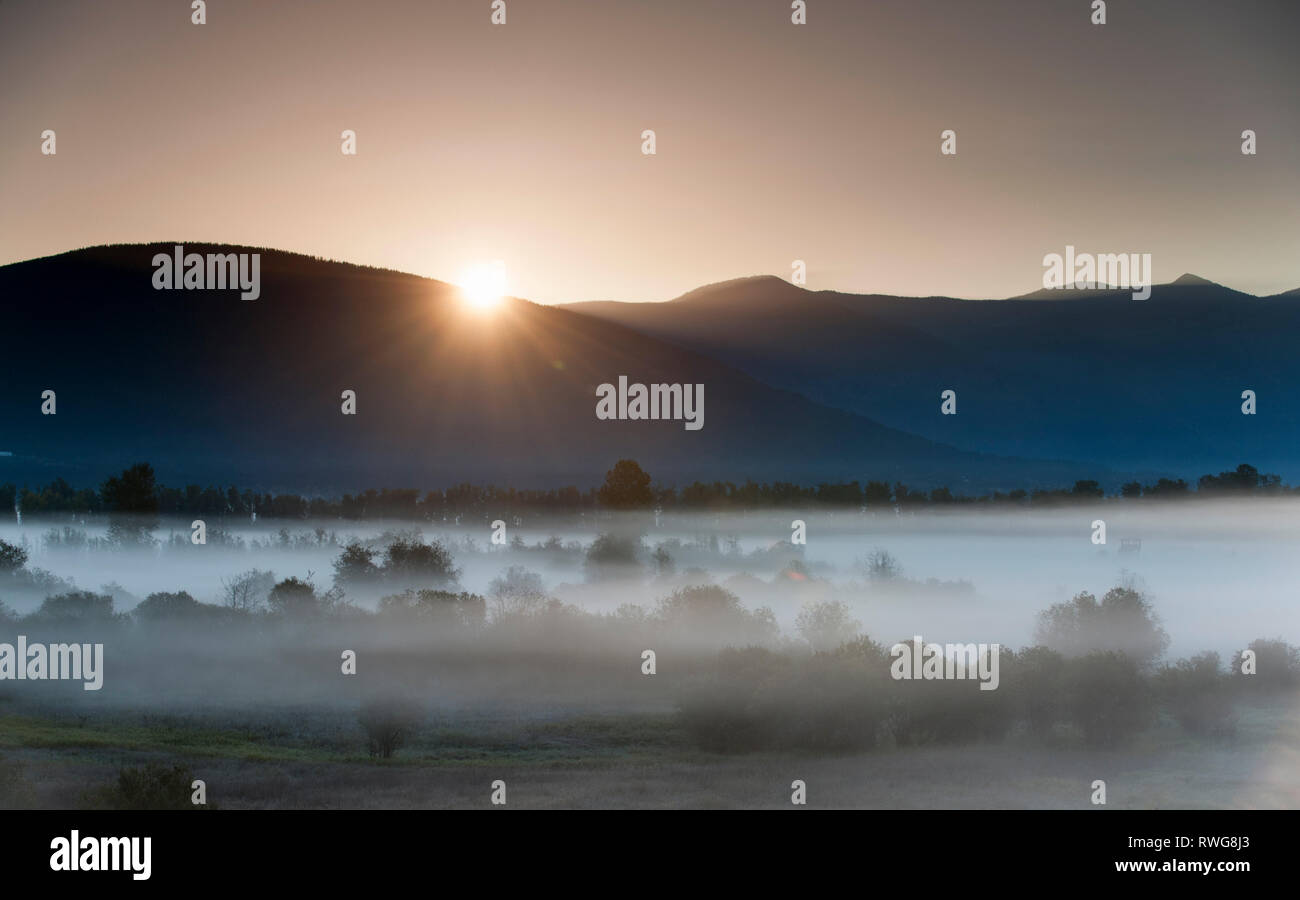 Sonnenaufgang und Nebel über Creston Valley, BC, Kanada Stockfoto