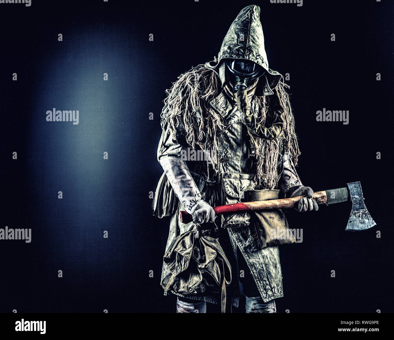 Post-apokalyptischen Überlebenden tragen Gasmaske und zerlumpten Kleider,  Bedrohung mit Ax Stockfotografie - Alamy