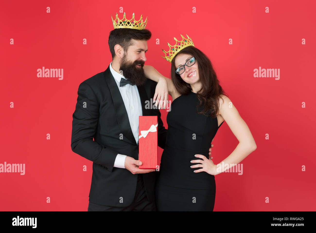 Royal Traditionen. Feiern Jubiläum. Royal Geschenk. König im Tuxedo goldene Krone, Geschenkbox Königin seines Herzens. Verliebtes Paar königliche Familie. Elite der Gesellschaft. König und Königin formale Veranstaltung. Stockfoto