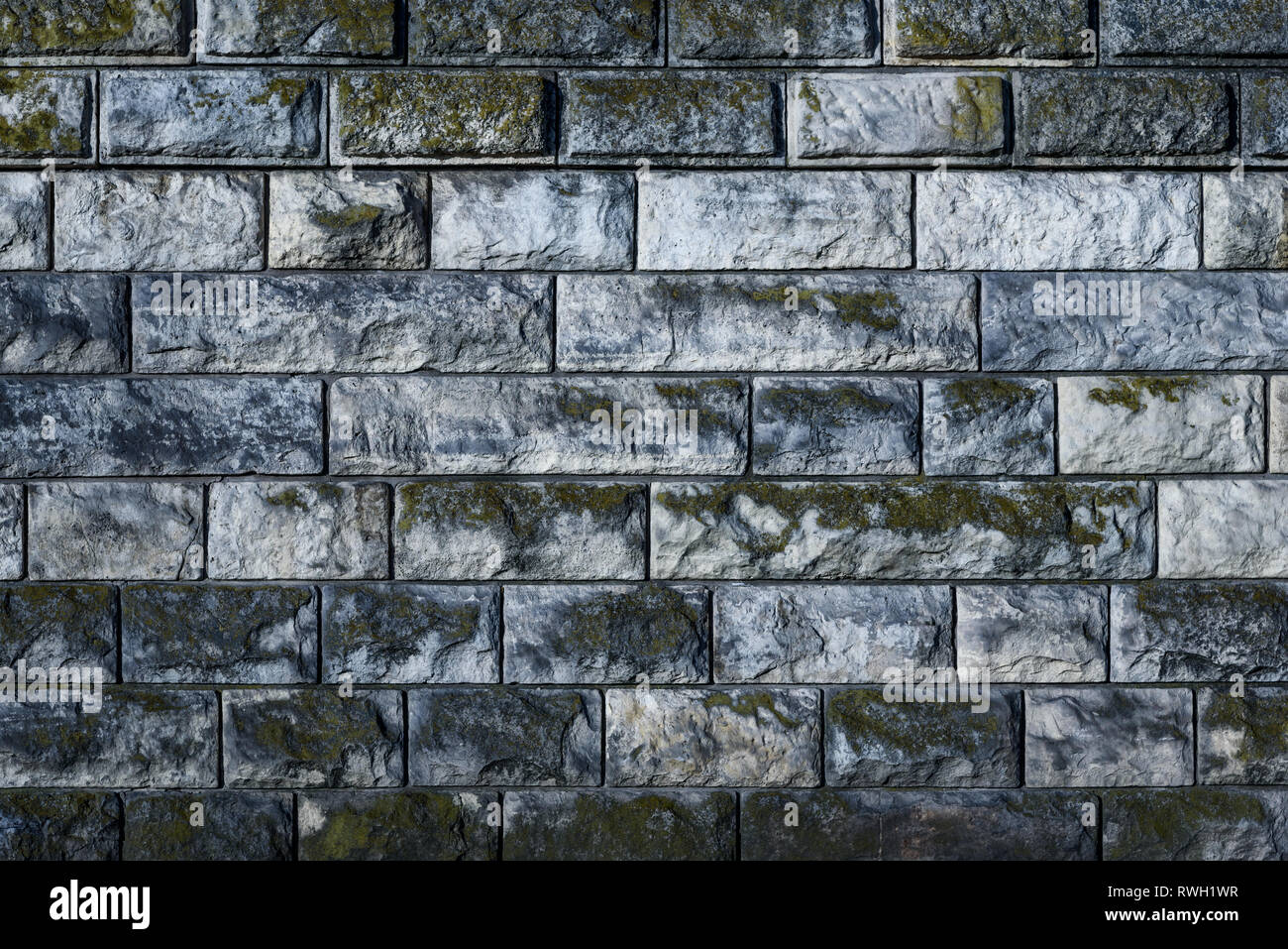Alte Mauer aus Stein bedeckt mit Moos als full frame Hintergrund (hoch) Stockfoto