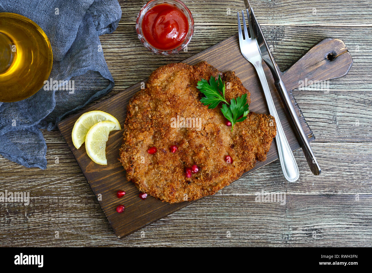 Große Wiener Schnitzel auf einer hölzernen Hintergrund. Fleischgericht. Ansicht von oben, flach. Stockfoto