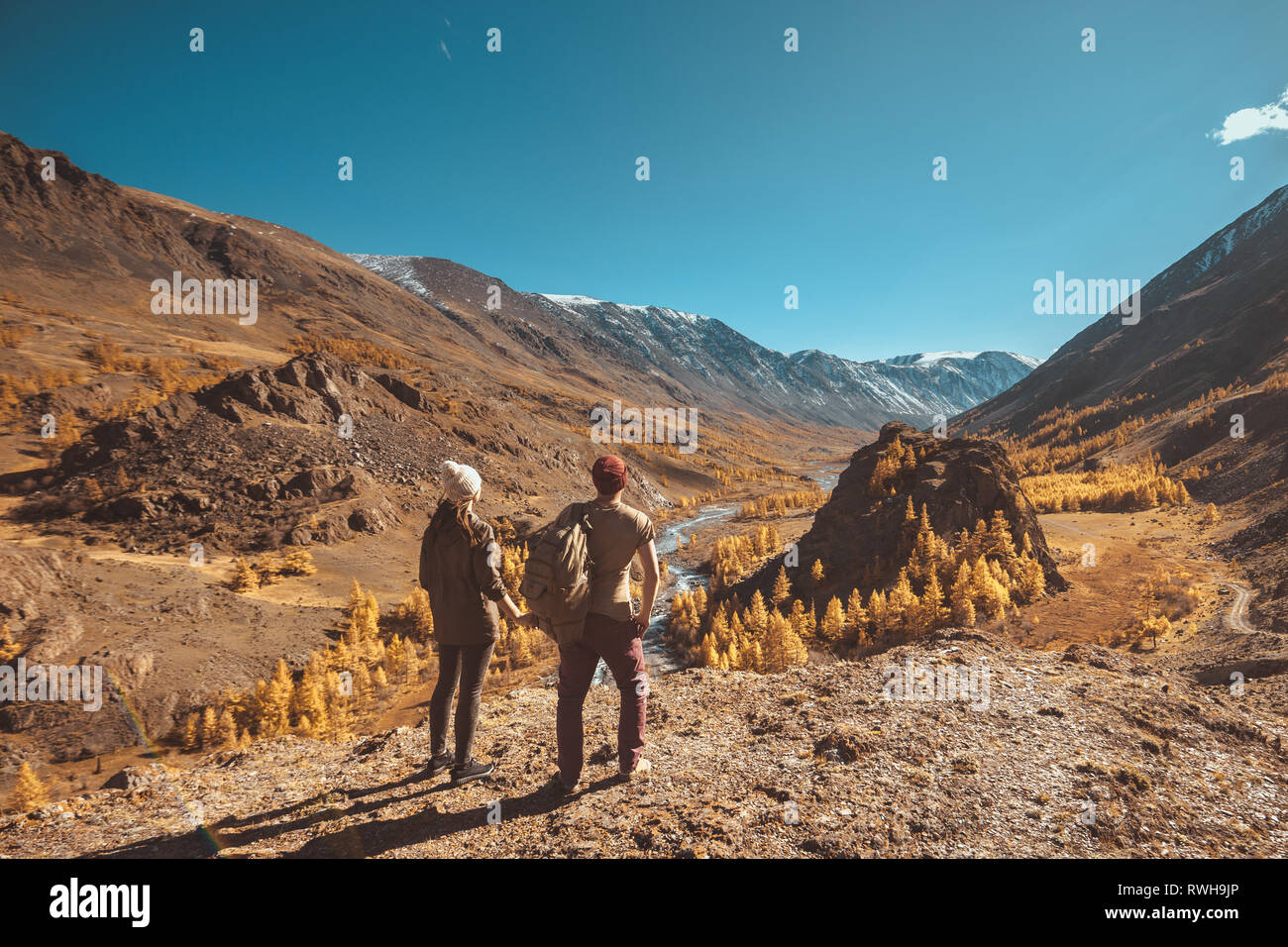 Zwei Wanderer steht auf einem großen Felsen und blickt auf die Berge, den Fluss und das Tal Stockfoto