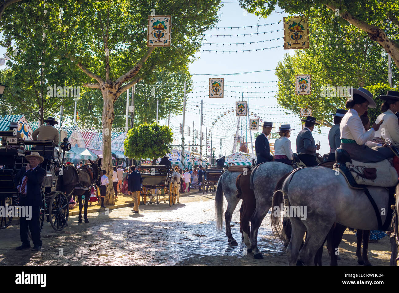 Reiter und Menschen in traditionellen Kostümen genießen April Messe. Sevilla Messe (Feria de Sevilla). Stockfoto