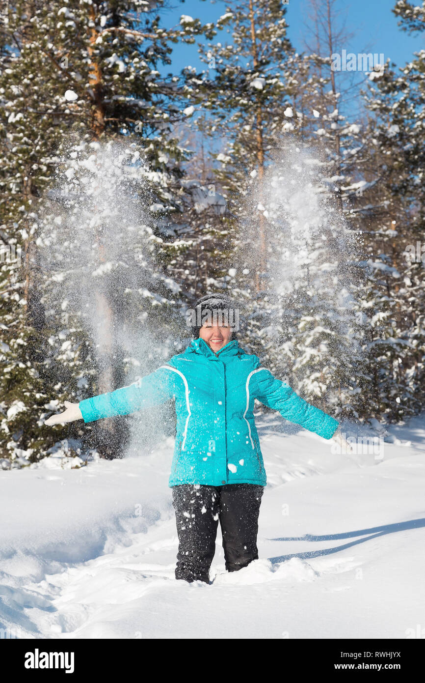 Neryungry Nerungry, Bezirk, Jakutien, Russland. Februar 5, 2017 Frau wirft Schnee im Winter Wald Stockfoto