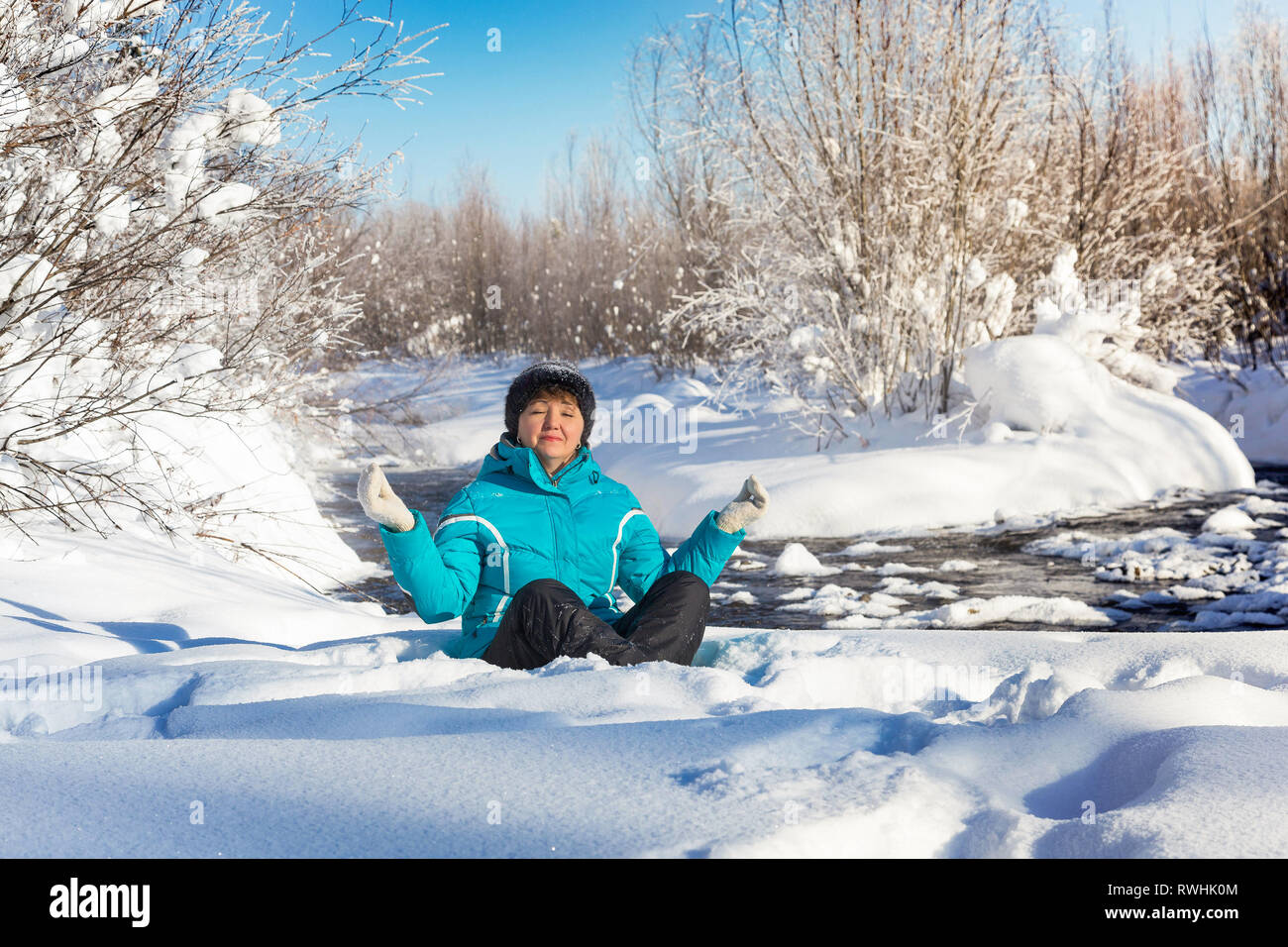Neryungry Nerungry, Bezirk, Jakutien, Russland. Februar 5, 2017 Frau im Lotossitz im Winter Wald bei schönem Wetter sitzen Stockfoto