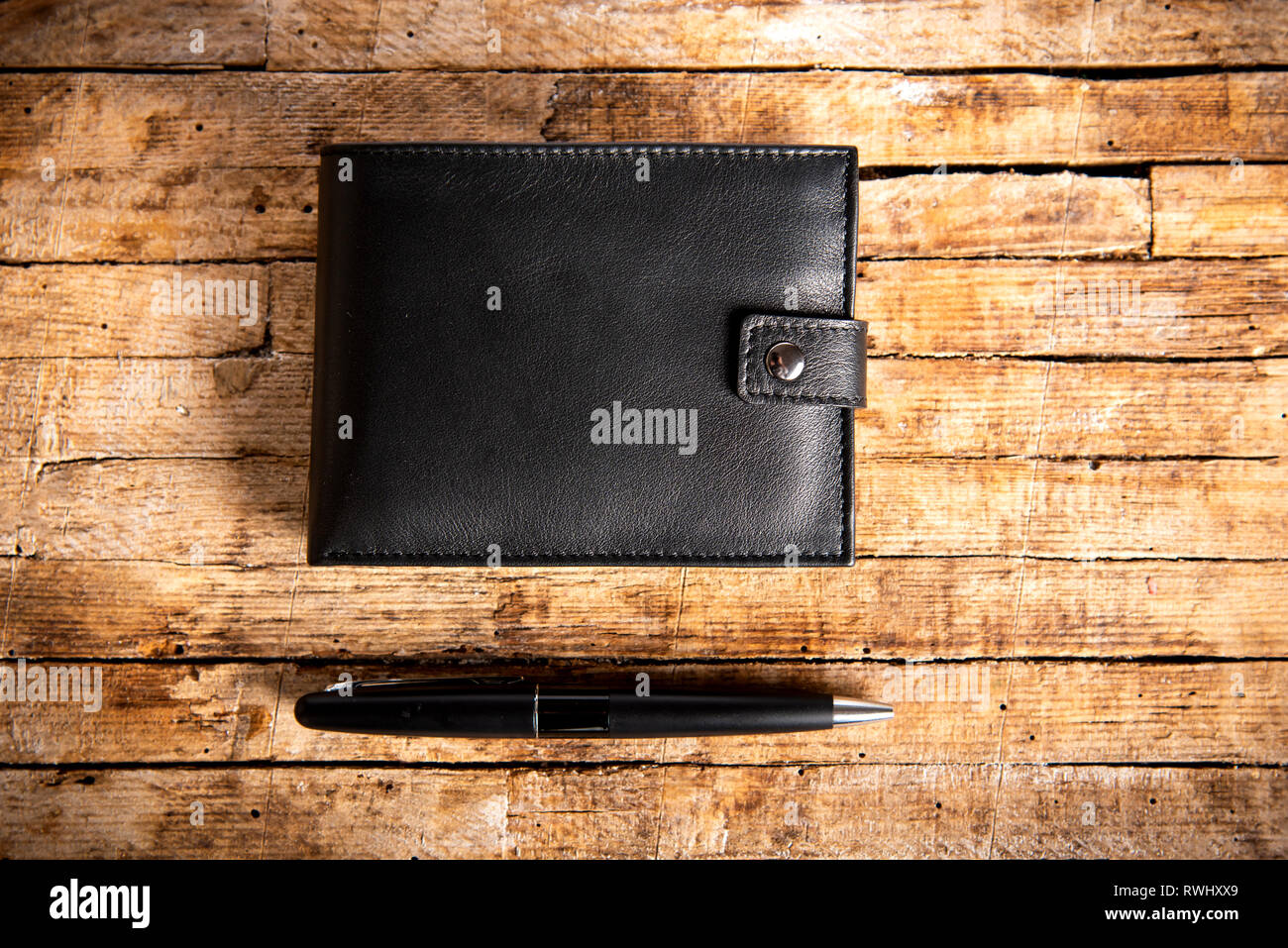 Schwarzes Leder-Etui und einen Bleistift auf einem Holztisch Stockfoto