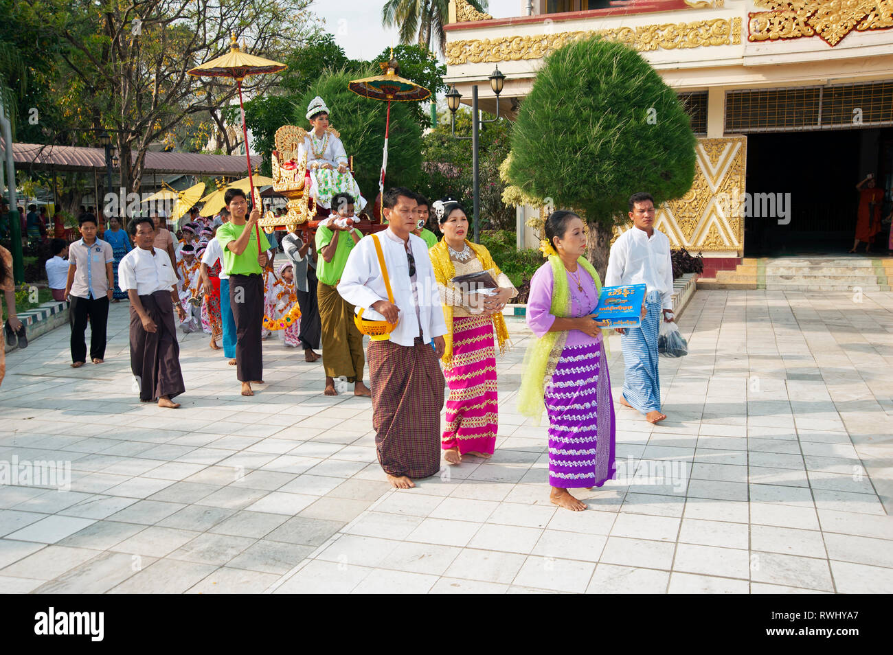Birmanischen Familie mit ihren bunt kostümierten stark Make-up boy Parade an ihre Volljährigkeit Zeremonie in Mandalay, Myanmar Stockfoto