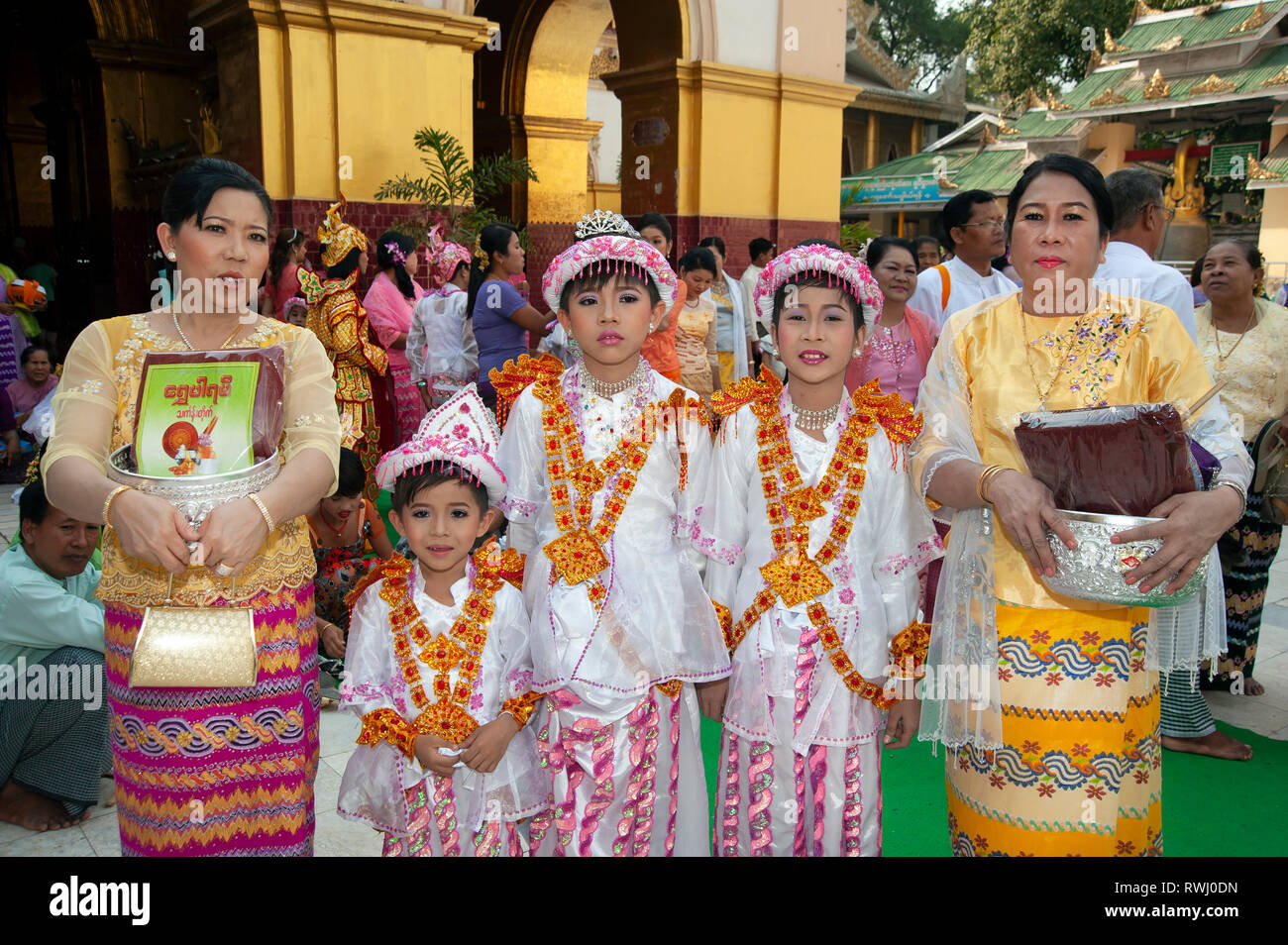 Stolz birmanischen Familie mit ihren bunt kostümierten stark Make-up Jungs an ihre Volljährigkeit Zeremonie in Mandalay, Myanmar Stockfoto
