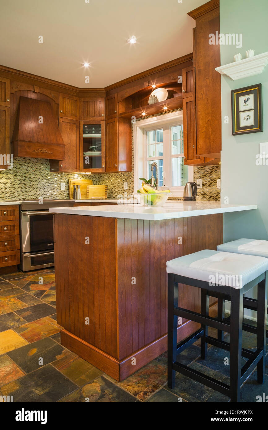 Küche mit Erdfarben, Schieferboden, Kirschbaum-Schränke und Insel mit