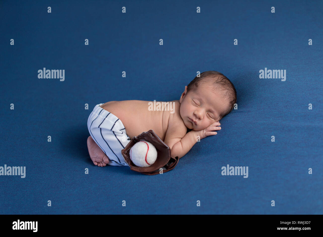 Eine Woche alt, Schlafen, neugeborenes Baby Boy tragen Baseball uniform Hose mit Mitt ist ein Blickfang und Ball. Stockfoto