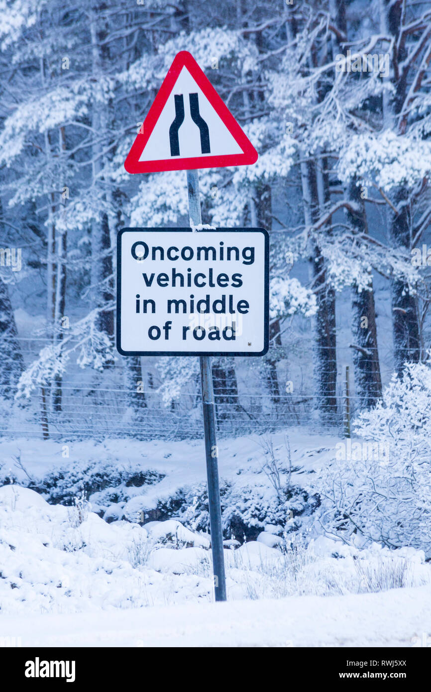 Entgegenkommende Fahrzeuge in der Mitte der Straße und Straße verengt auf beiden Seiten der Straße der Beschilderung auf der A82 Straße an einem kalten Wintermorgen an Rannoch Moor, Argyll, Schottland Stockfoto