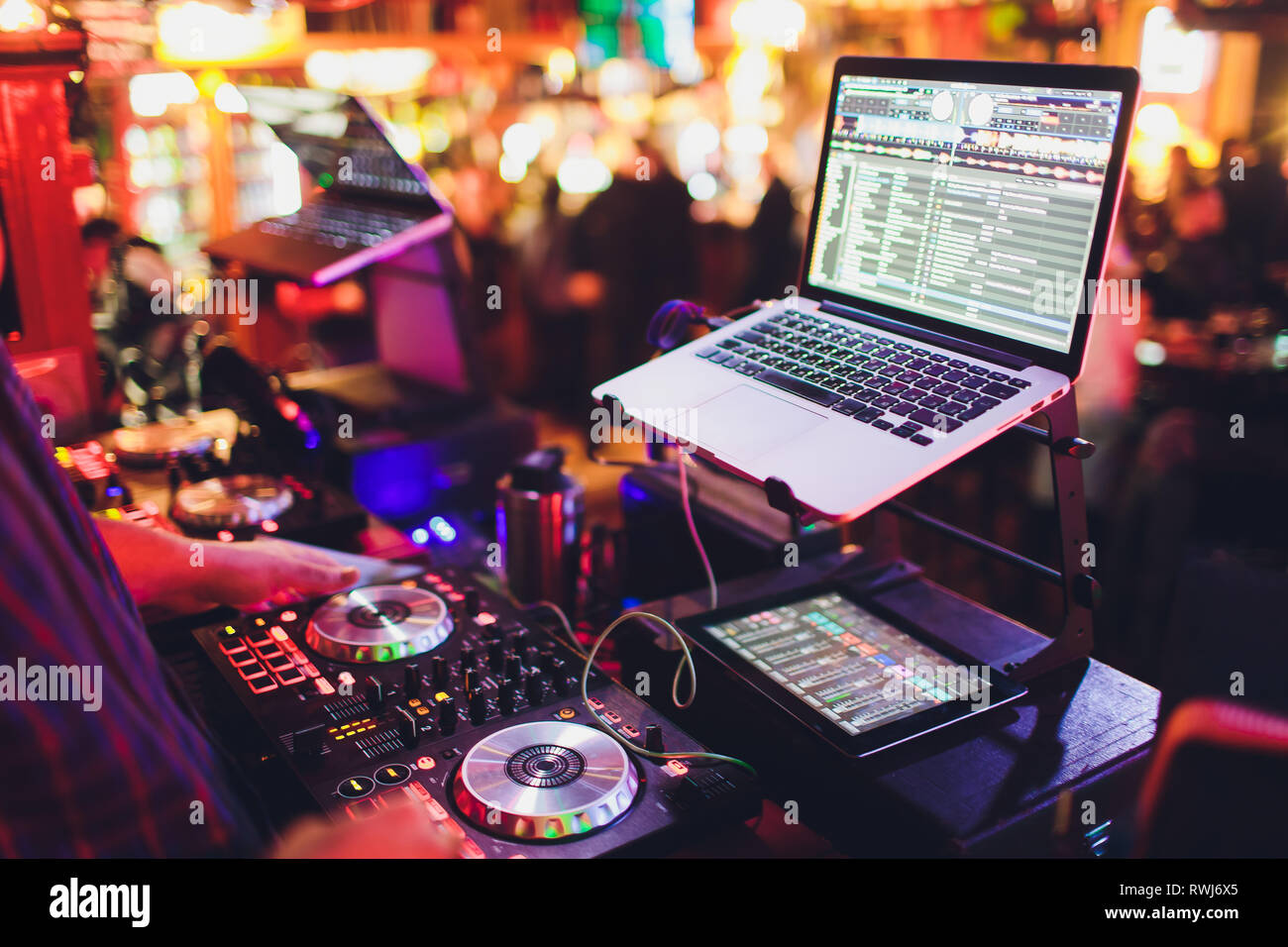 Hände von DJ Mix Tracks auf digitale Drehscheibe und Software auf Laptop mit Professional Mixing Software. Disc Jockey spielen Musik zeigen Stockfoto