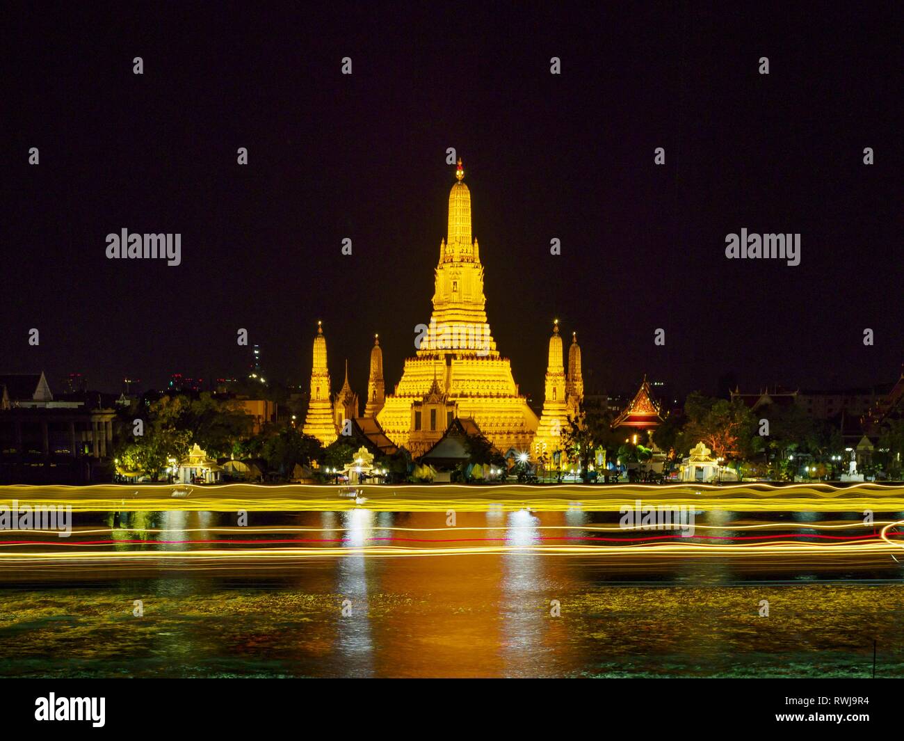 März 6, 2019 - Bangkok, Bangkok, Thailand - Schiffsverkehr auf dem Fluss Chao Phraya geht vorbei Wat Arun kurz nach Sonnenuntergang. Wat Arun Ratchawararam Ratchawaramahawihan oder Wat Arun (Tempel der Morgenröte'''') ist ein buddhistischer Tempel (Wat) in Bangkok auf der Thonburi Seite des Chao Phraya. Der Tempel leitet seinen Namen von dem hinduistischen Gott Aruna, die wie die aufgehende Sonne personifiziert ist. Wat Arun gehört zu den bekanntesten der thailändischen Tempeln. Der Tempel hat mindestens seit dem siebzehnten Jahrhundert existierte, aber seine unverwechselbare Prang (Türme) wurden im Khmer Stil im frühen neunzehnten Jahrhundert während der gebaut Stockfoto