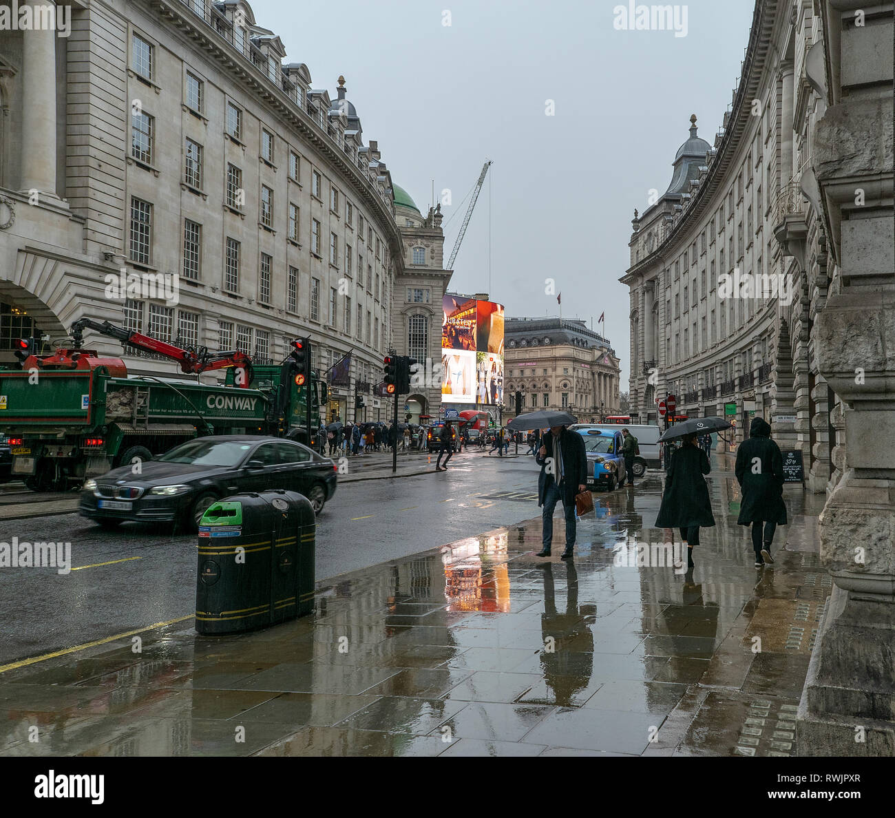 Piccadilly Circus, London im Regen mit den Reflexionen auf den Gehwegen Stockfoto