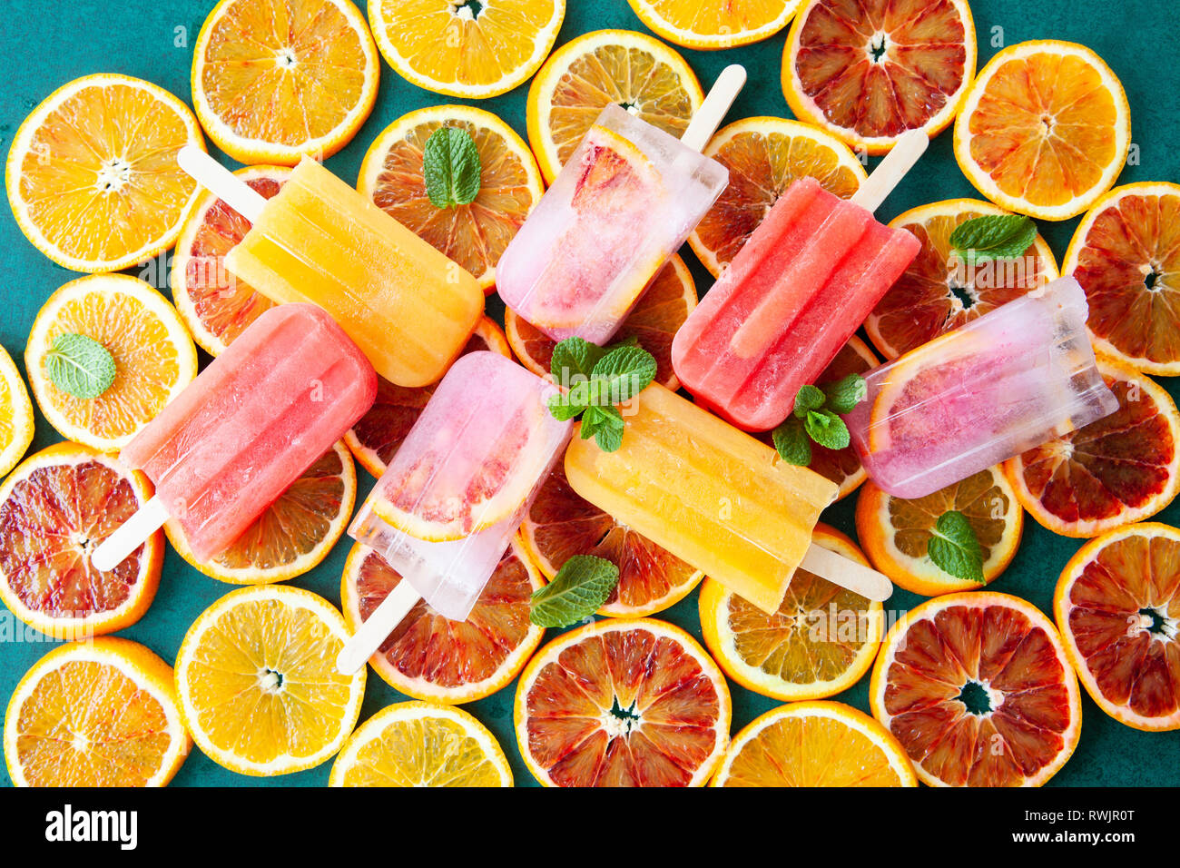 Gefrorene Eis am Stiel mit frischen Zitrusfrüchten und Minzeblättchen Stockfoto