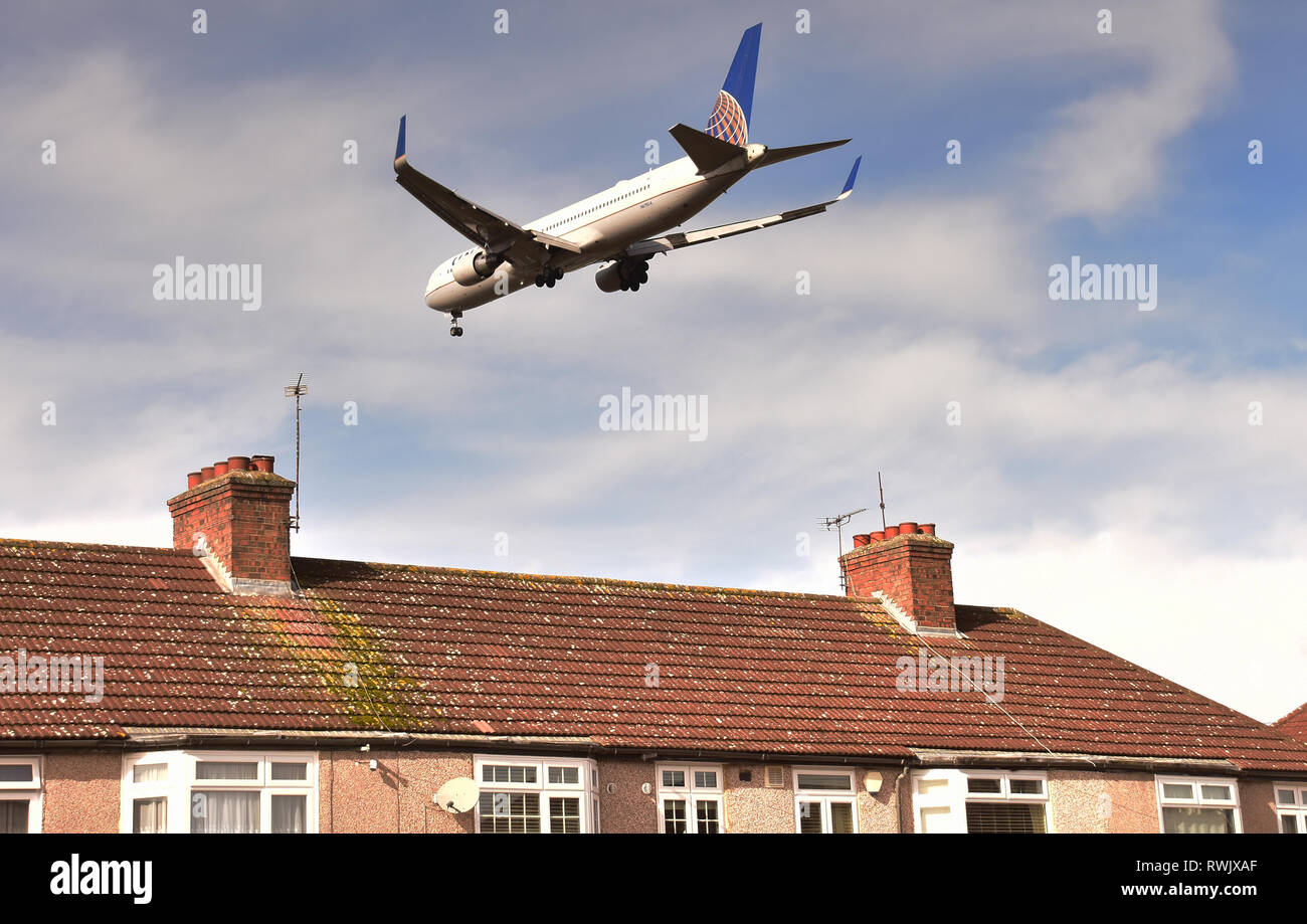 Tief fliegenden Flugzeug Landung am Flughafen Heathrow, London über die Häuser Stockfoto