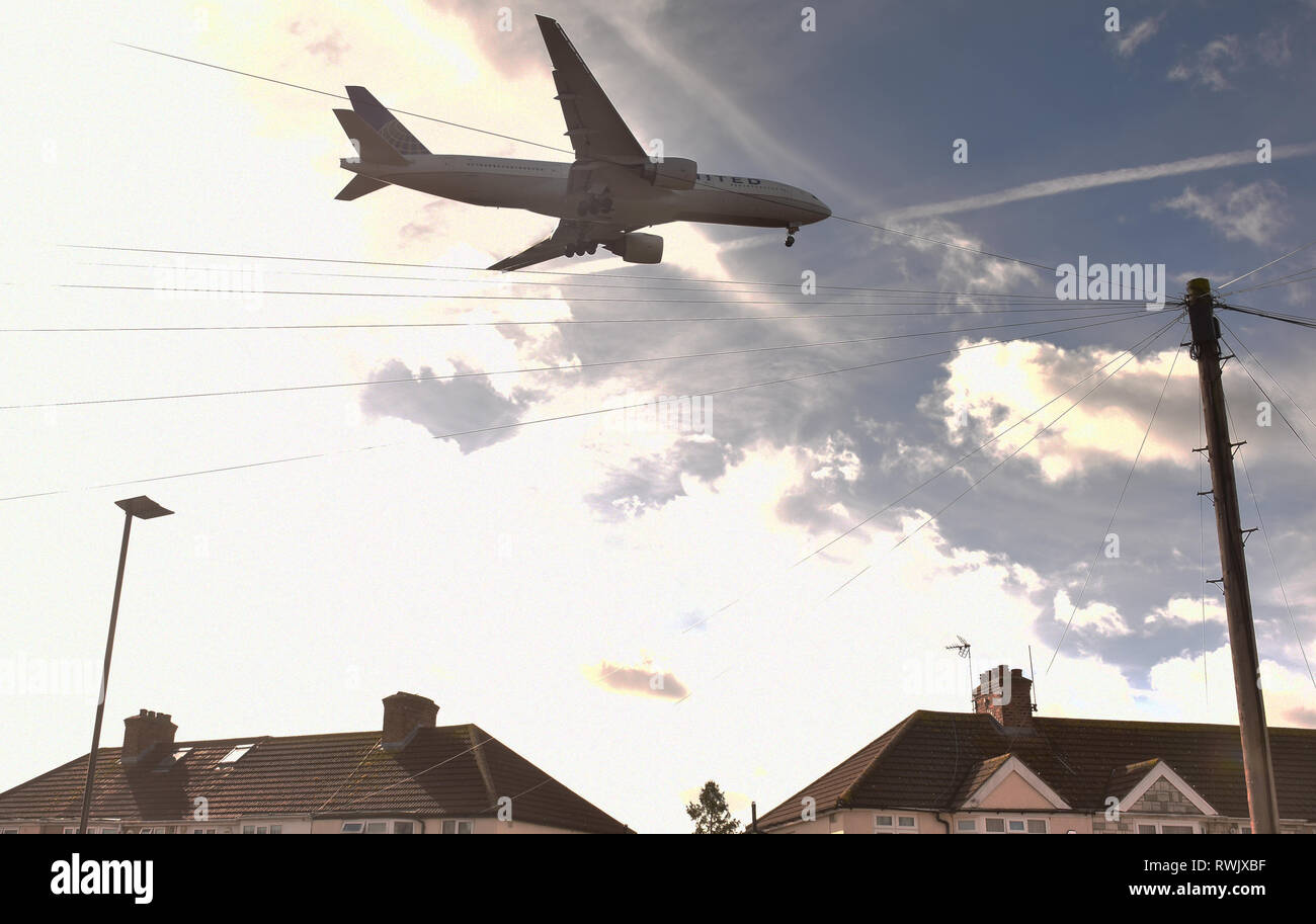 Tief fliegenden Flugzeug Landung am Flughafen Heathrow, London über die Häuser Stockfoto