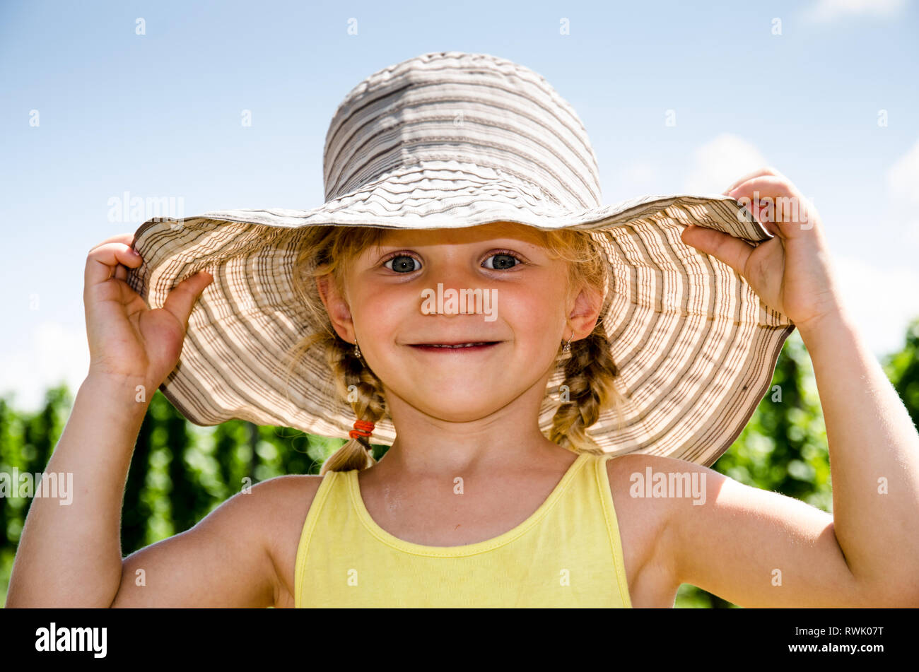 Schöne kleine blonde Mädchen mit Hut Stockfoto