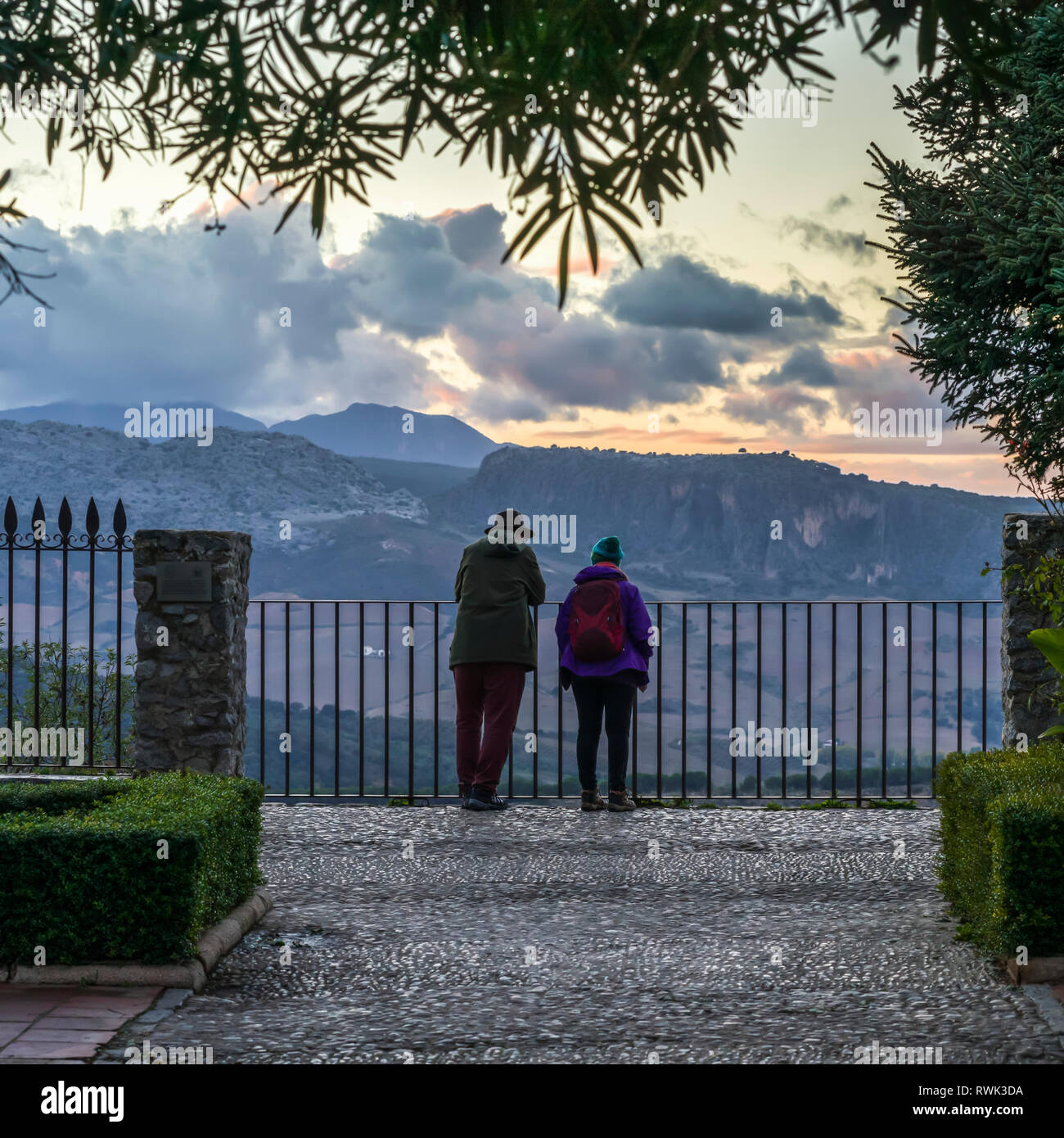 Ein junges Paar steht an einem Zaun mit Blick über die Landschaft von Ronda bei Sonnenuntergang; Ronda, Provinz Malaga, Spanien Stockfoto