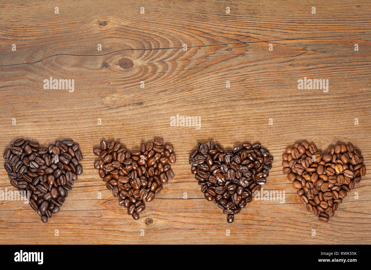Ansicht von oben der Kaffeebohne Herzen auf braunem Holz- Hintergrund Stockfoto
