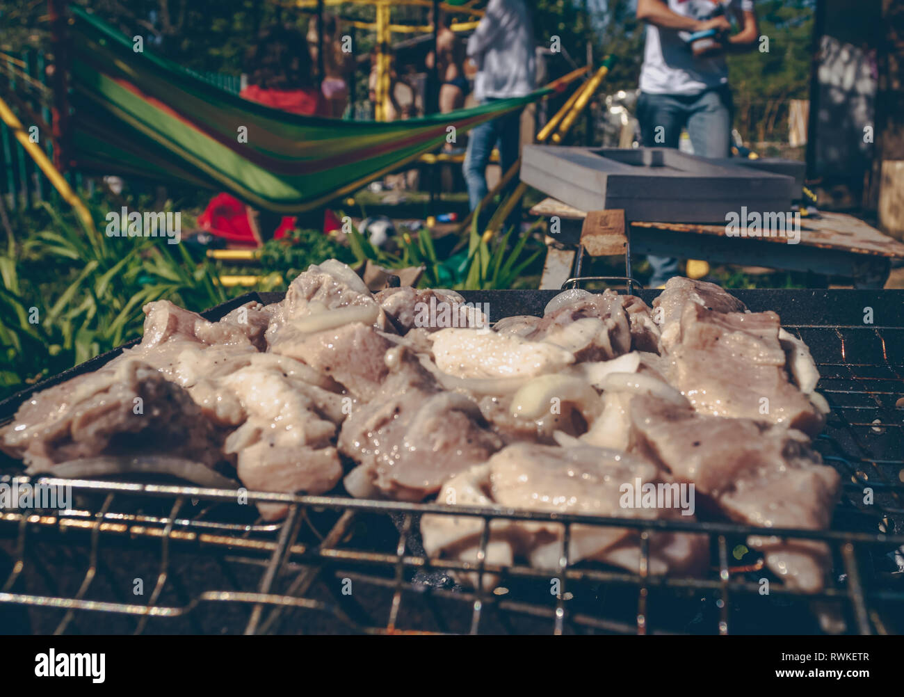 Barbecue Party Konzept mit gebratenem Fleisch und verschwommenes unbekannter Menschen auf Hintergrund Stockfoto
