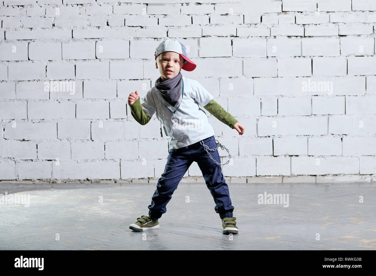 Kind Junge Modell im angesagten rapper Kleidung posieren. studio, ziegelwand Hintergrund. Cool junge Tanz break dance. Hip-Hop-Stil. Stockfoto