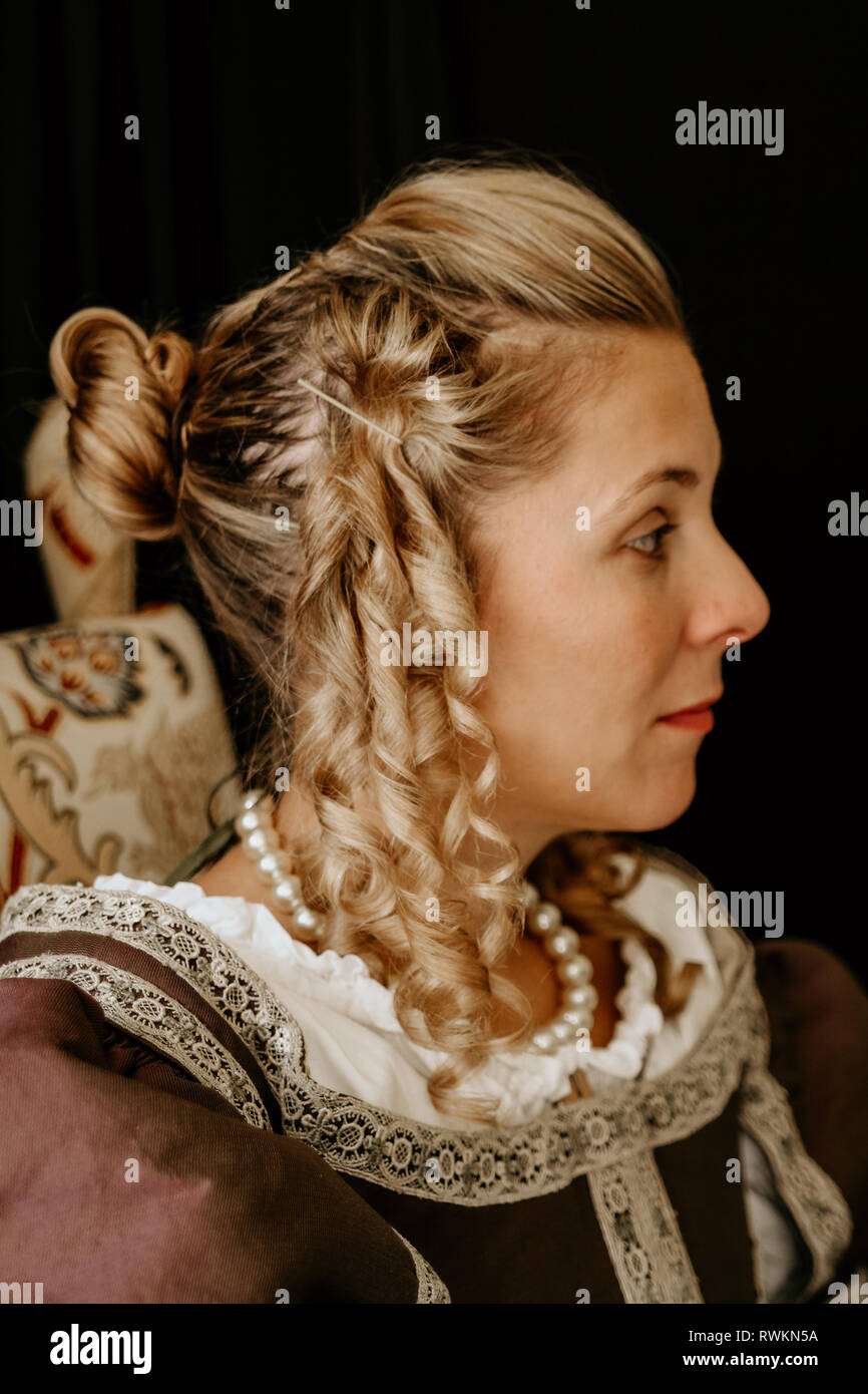 Porträt einer schönen jungen Frau in prunkvollen historischen Kleid - ihre Kleidung in Ordnung sind, die Sie trägt Perlen um den Hals & hat gewellte blonde Haare. Stockfoto