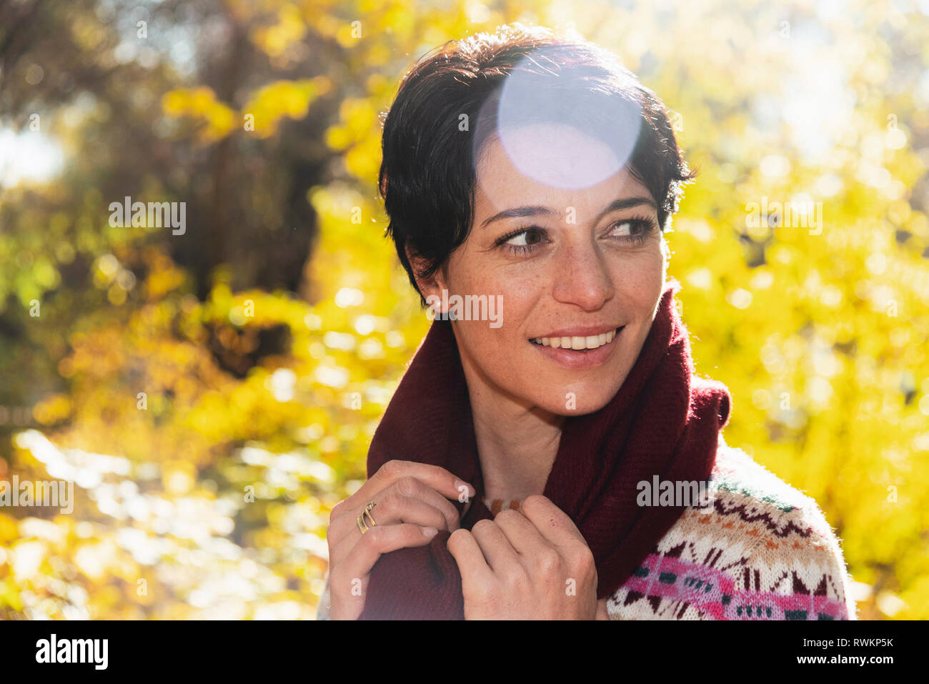 Lächelnde Frau im herbstlichen Wald Stockfoto