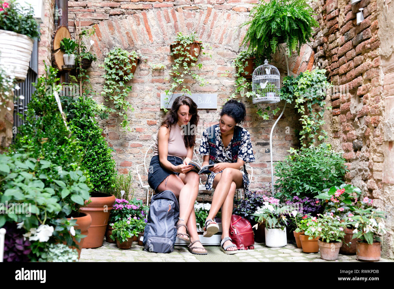 Freunde in ruhiger Ecke mit Pflanzen, Città della Pieve, Umbrien, Italien Stockfoto