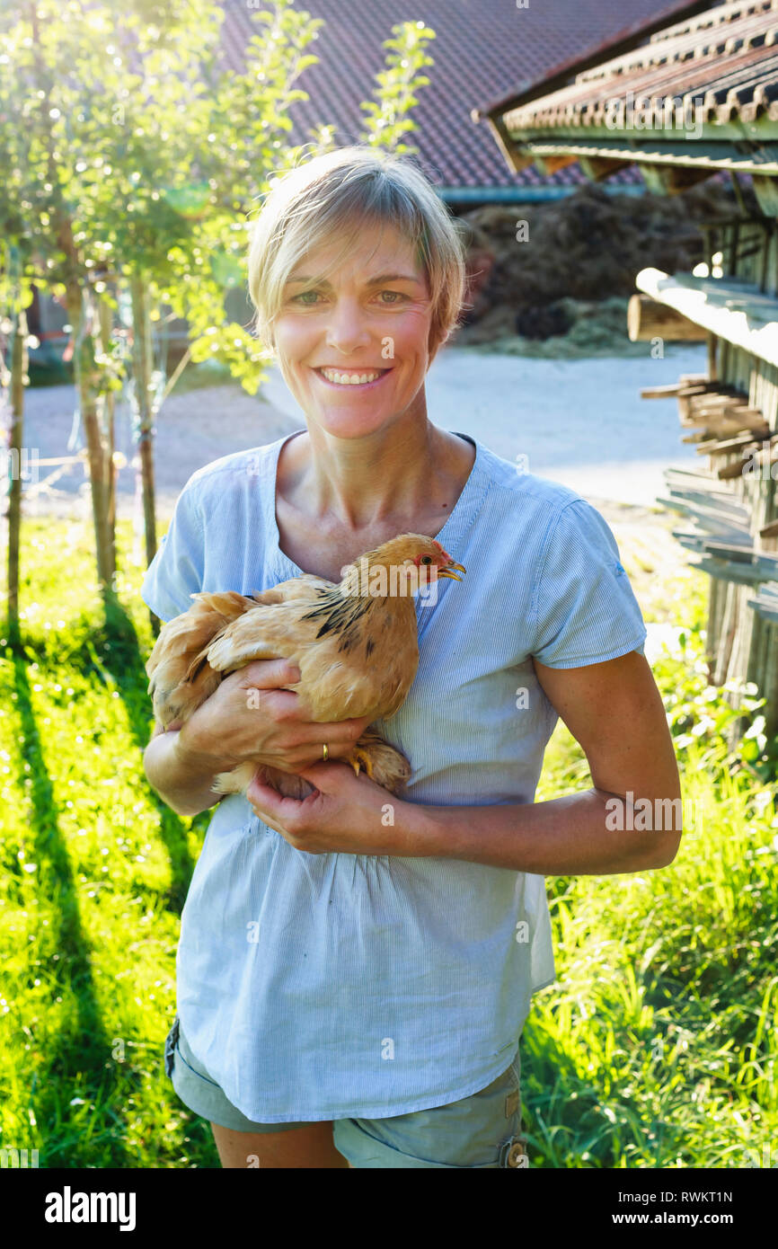Frau, die Henne in der Landschaft, Sonthofen, Bayern, Deutschland Stockfoto