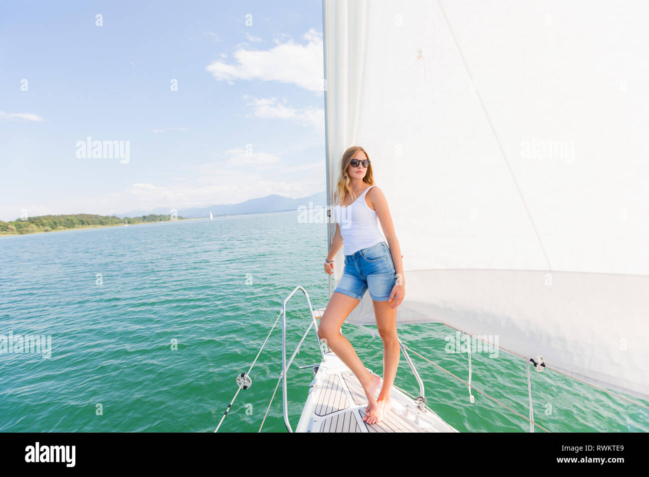 Junge Frau auf Segelboot auf Chiemsee, Porträt, Bayern, Deutschland Stockfoto