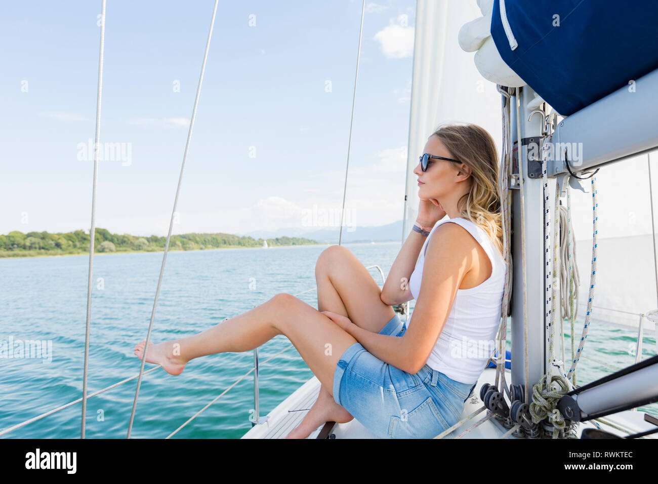 Junge Frau Segeln auf dem Chiemsee, Bayern, Deutschland Stockfoto