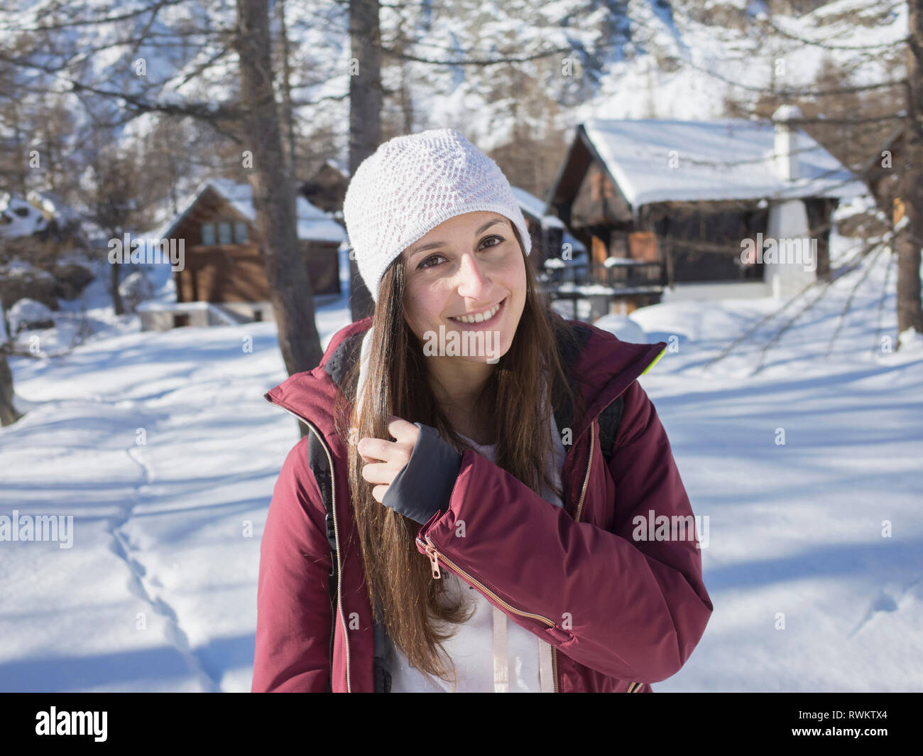 Junge Frau in Strick Hut im verschneiten Wald, Porträt, Alpe Ciamporino, Piemont, Italien Stockfoto