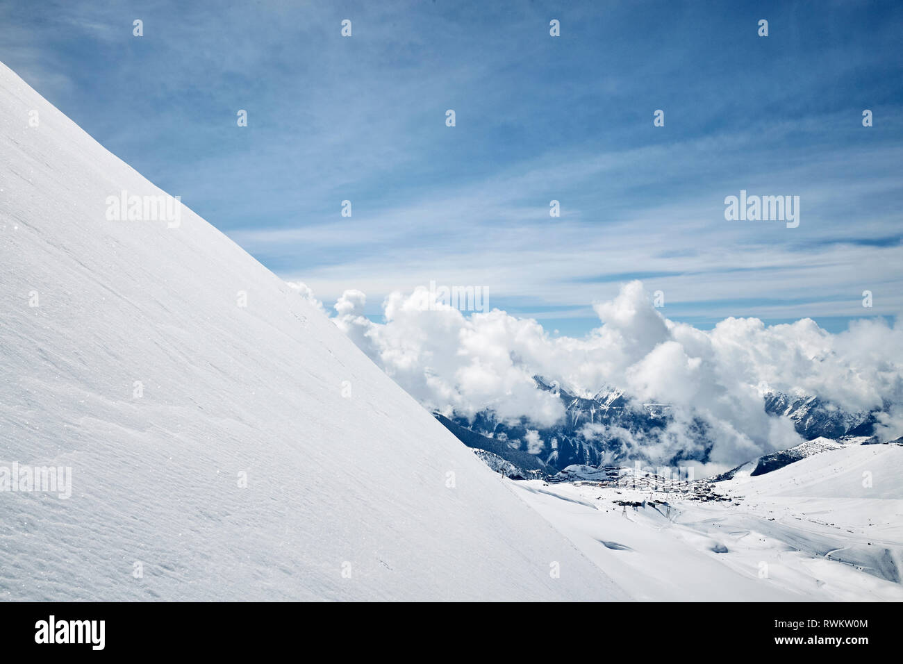 Verschneite Landschaft von niedrigen Wolken über den Bergen, Erhöhte Ansicht, Alpe-d'Huez, Rhône-Alpes, Frankreich Stockfoto