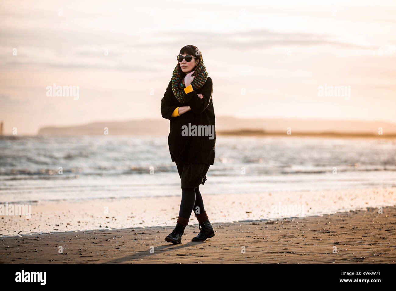 Frau alleine zu Fuß am Strand. Stockfoto