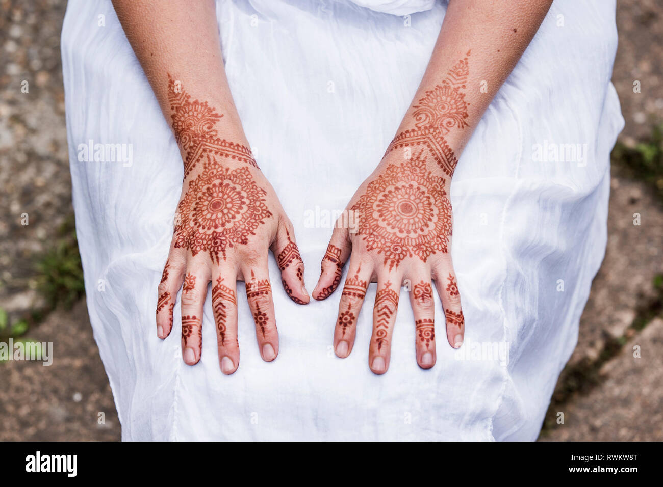 Frau in weißem Kleid mit Henna Tattoo auf Händen Stockfoto