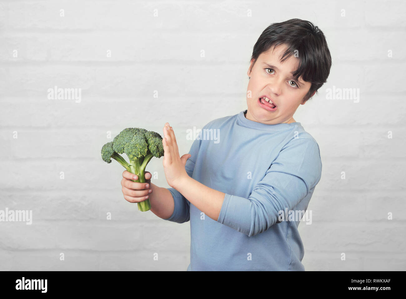 Kind nicht zu Brokkoli gegen Ziegel Hintergrund wie Stockfoto