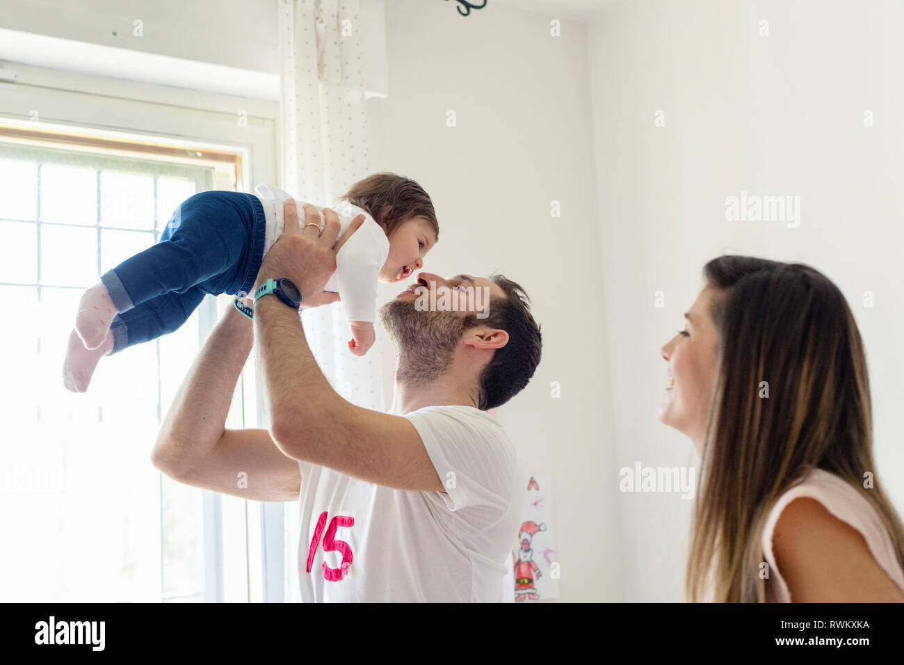 Eltern mit Babymädchen zu Hause spielen Stockfoto
