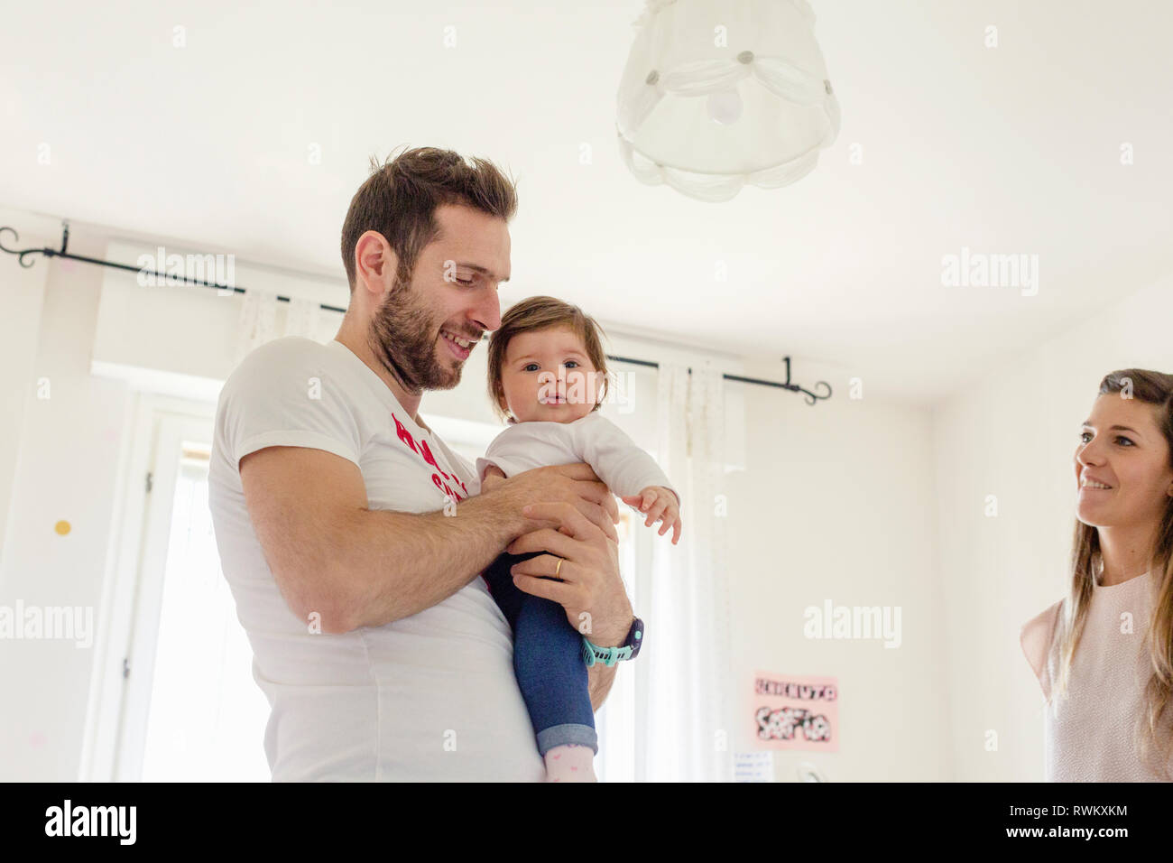 Eltern mit Babymädchen zu Hause spielen Stockfoto