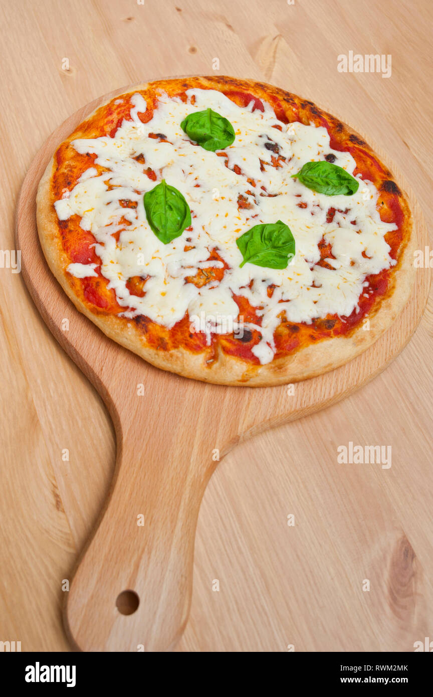 Warme pizza bereit auf einer hölzernen Servierteller Stockfoto