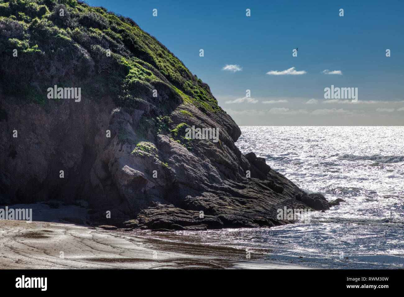 Malerische Küste Blick auf riesige Klippen am Strand steht, an einem sonnigen Tag mit Spiegelungen im Wasser, Dana Point, Kalifornien Stockfoto