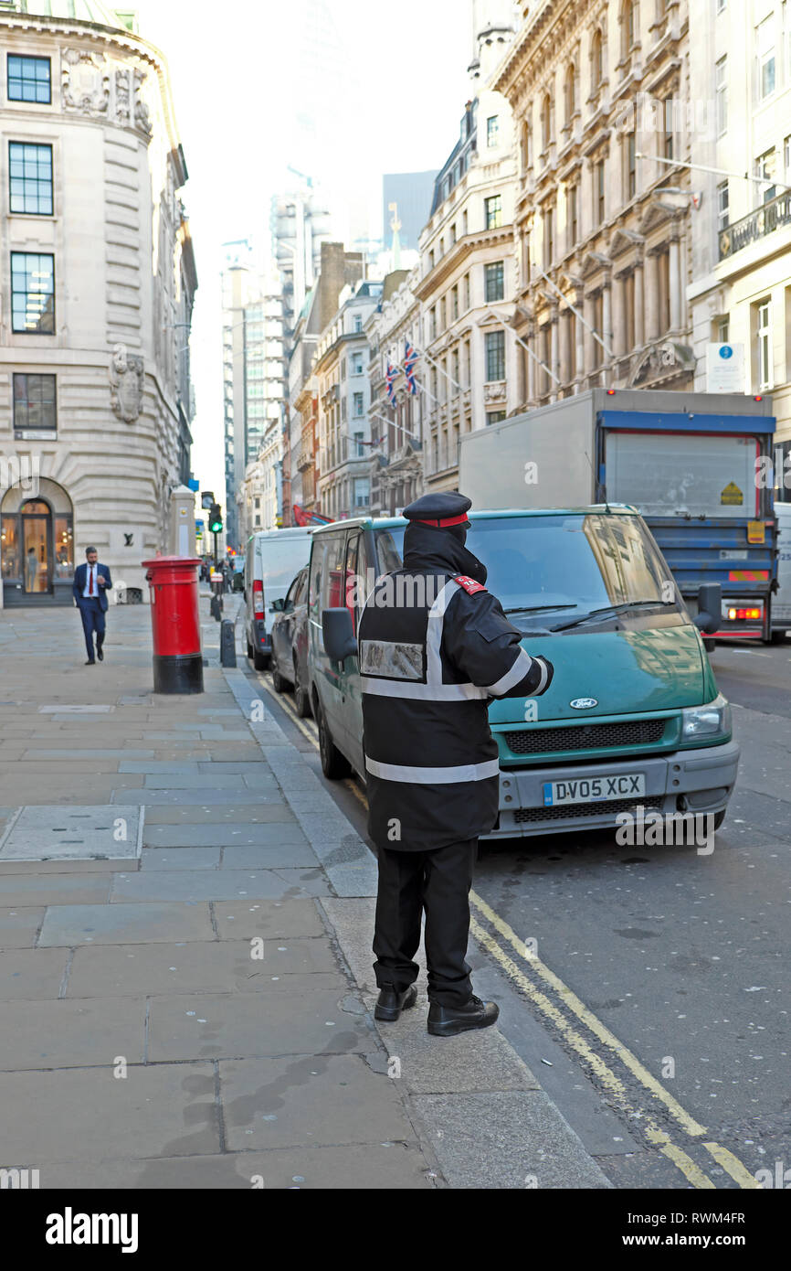 Ein Parkplatzwächter, der einem Van, der auf der gelben Doppellinie im Geschäftsviertel Cornhill in der Londoner City geparkt ist, ein Ticket ausgibt, KATHY DEWITT Stockfoto
